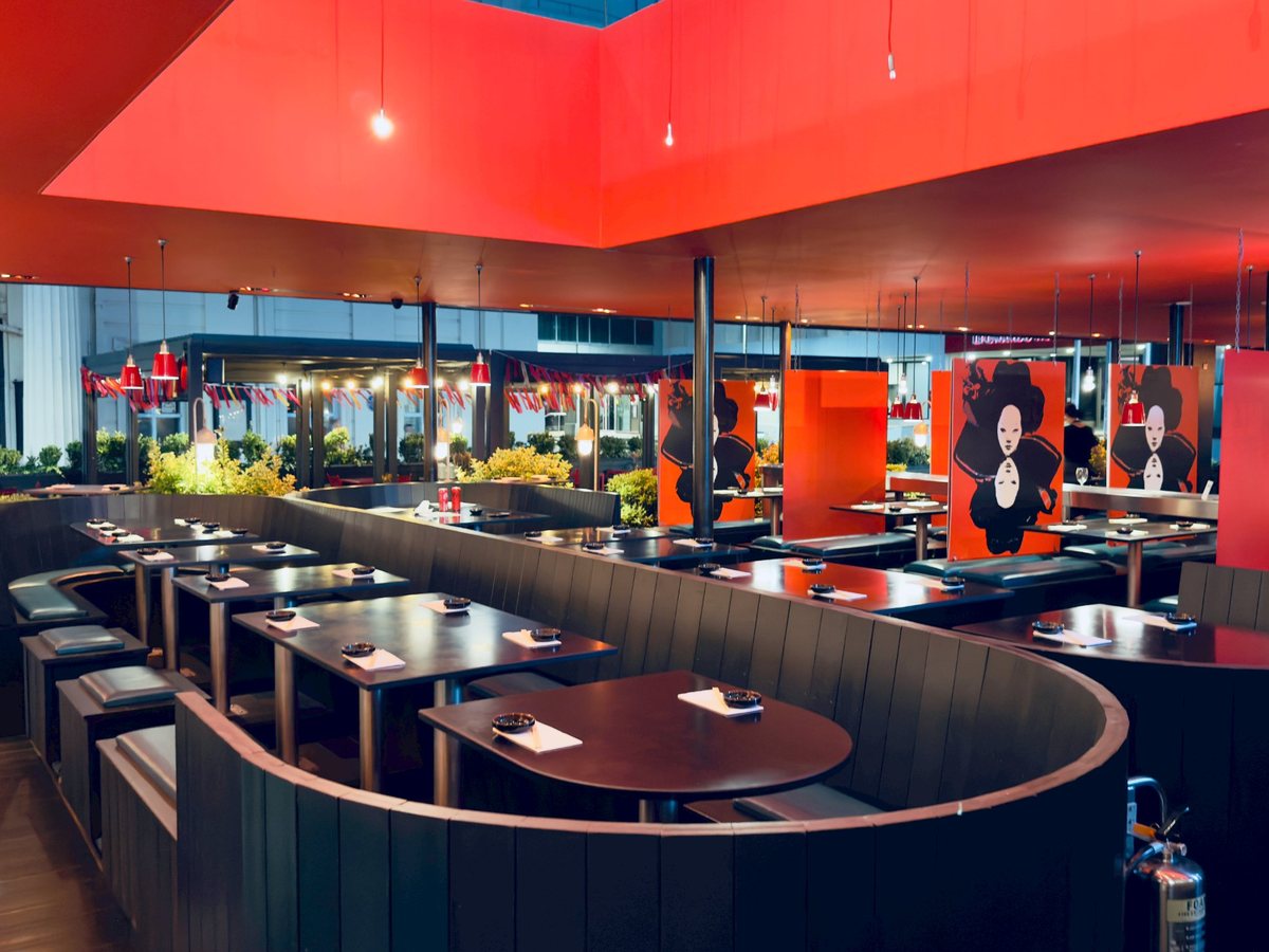 The curved group seating laid up under the red ceiling, the deck beyond